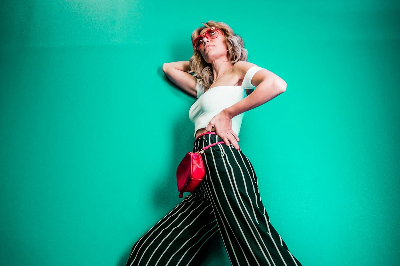 Woman wearing a structured cobalt blue blazer over a cream silk blouse and burnt-orange wide-leg trousers, color blocking fashion editorial